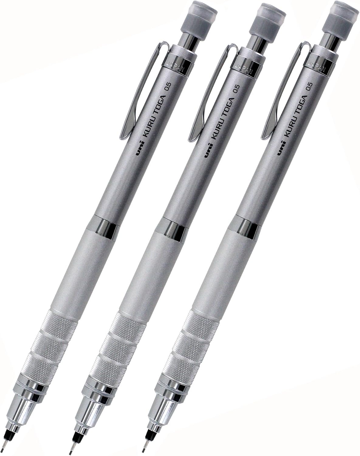 Three silver uni Kuru Toga Roulette 0.5 mm mechanical pencils in a row, knurled grips at the front and JAPAN stamped on every clip